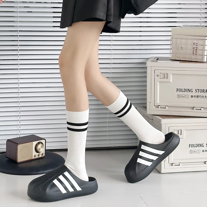 une paire de chaussettes pour fille simples et polyvalentes avec un design patchwork noir et blanc pour le printemps et l'automne. une paire de chaussettes pour fille simples et polyvalentes avec un design patchwork noir et blanc pour le printemps et l'automne.