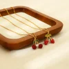 collier à breloques en forme de fleur de cerisier, pendentif en acier inoxydable plaqué or 18 carats avec détails en émail rouge, bijoux étanches, cadeau pour fille