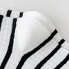 une paire de chaussettes pour fille simples et polyvalentes avec un design patchwork noir et blanc pour le printemps et l'automne.