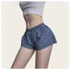 culotte carrée fine à carreaux rouges et verts pour femmes, portée sous un pantalon à jambes larges, style de rue américain